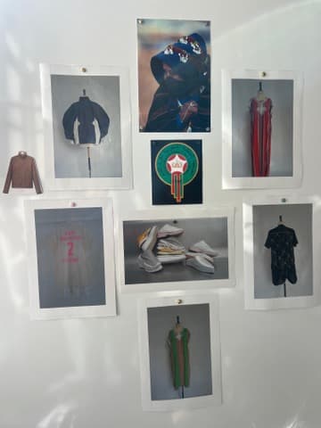 Mood board pinned to a wall with a hooded look, a red gown, a Moroccan emblem, sneakers and a green look